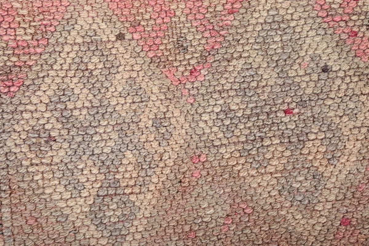 Macro view of the rug's low pile, revealing individual wool knots and subtle color variations.