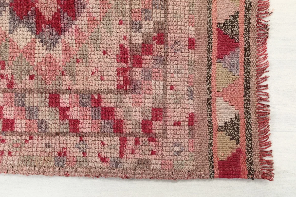 Detailed view of the rug's end, showing the hand-knotted texture and fringe