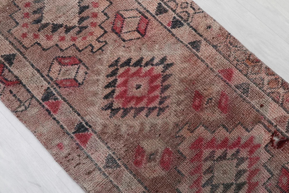Close-up of the runner rug's geometric motifs, showing the low pile and color variations