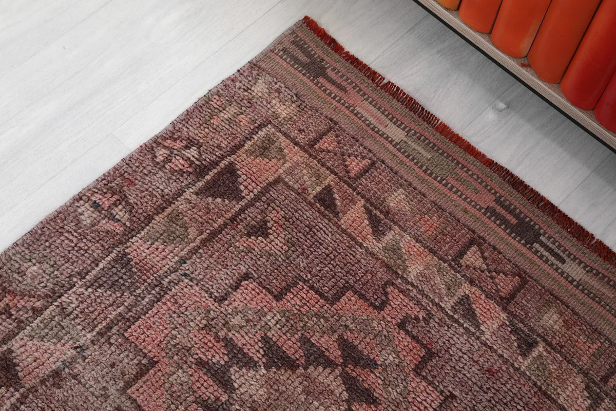 Detailed corner view of the runner rug, showing the intricate border design and muted tones