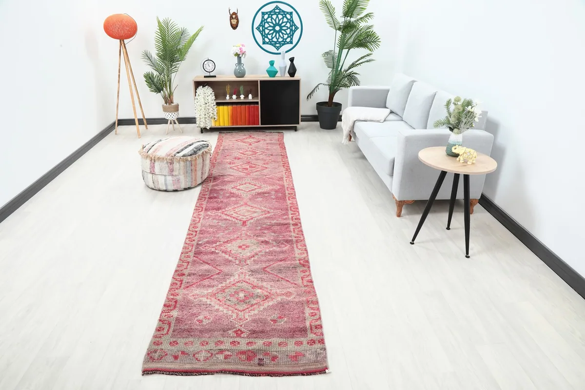 Rose runner rug displayed in a modern living room setting with light furniture and plants