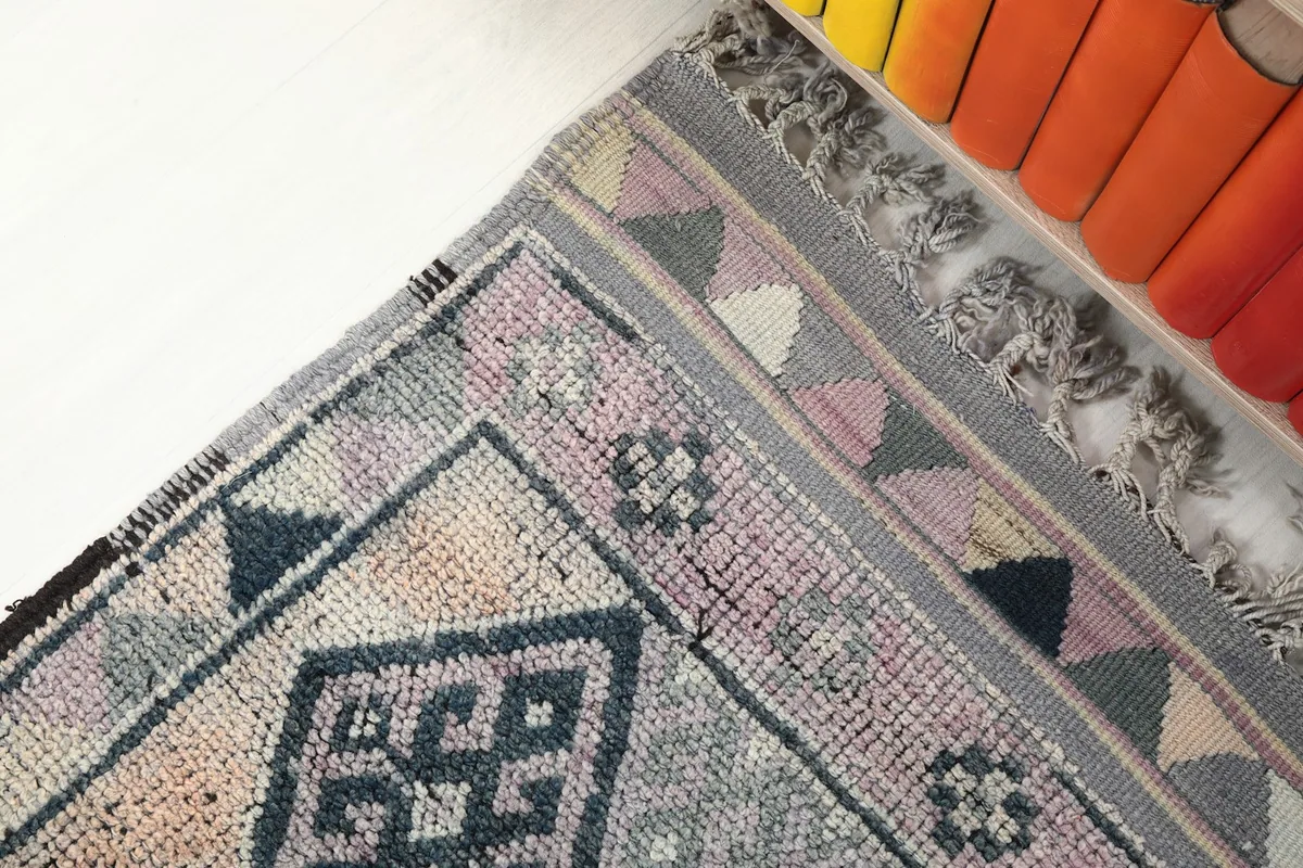 Close-up of the rug's border, showcasing the intricate triangle motifs and fringe detail