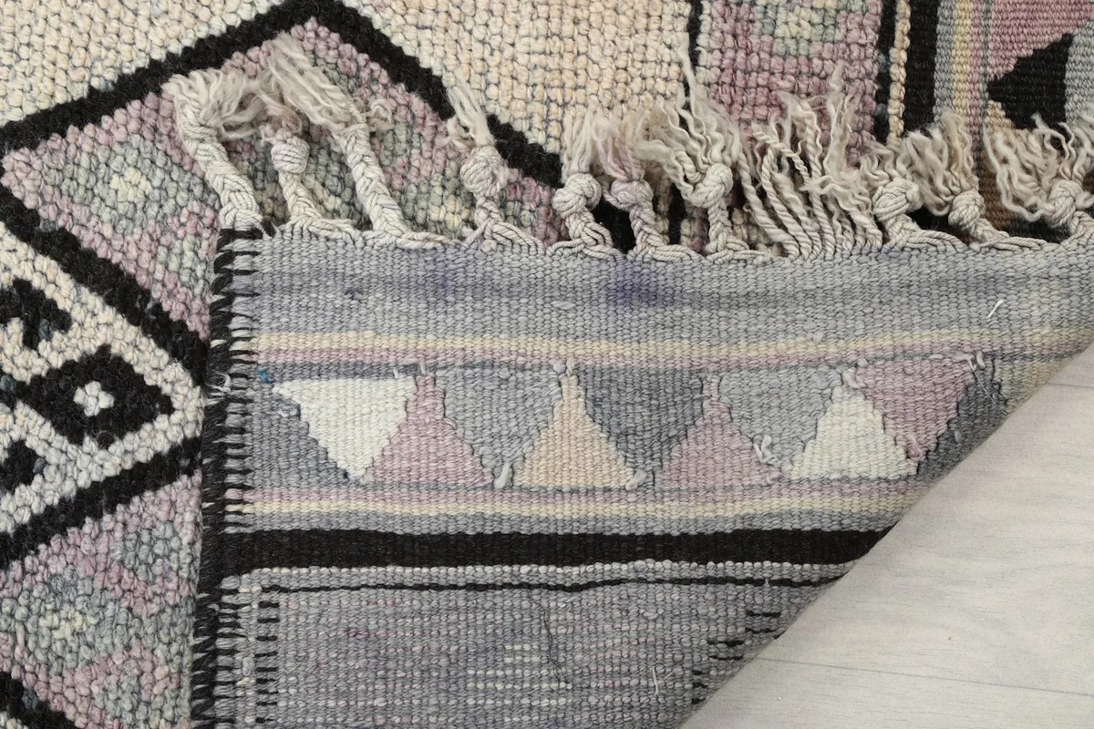 Close-up of the back of the rug, showing the hand-knotted construction and fringe details