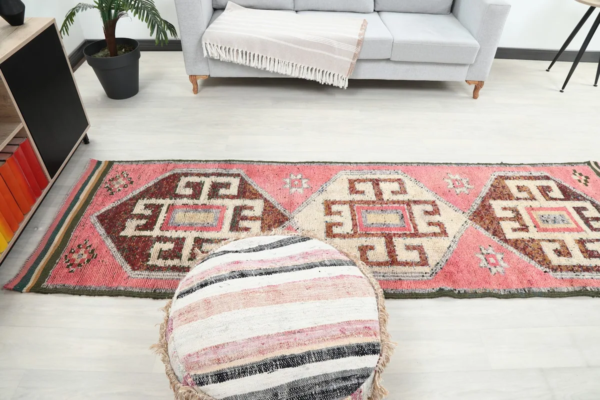 Full length view of the pink runner rug extending into a living space, adding color to the hallway area.