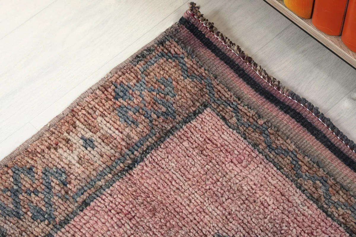 Close-up of the low wool pile and the texture of the hand-knotted surface, showing color variations.