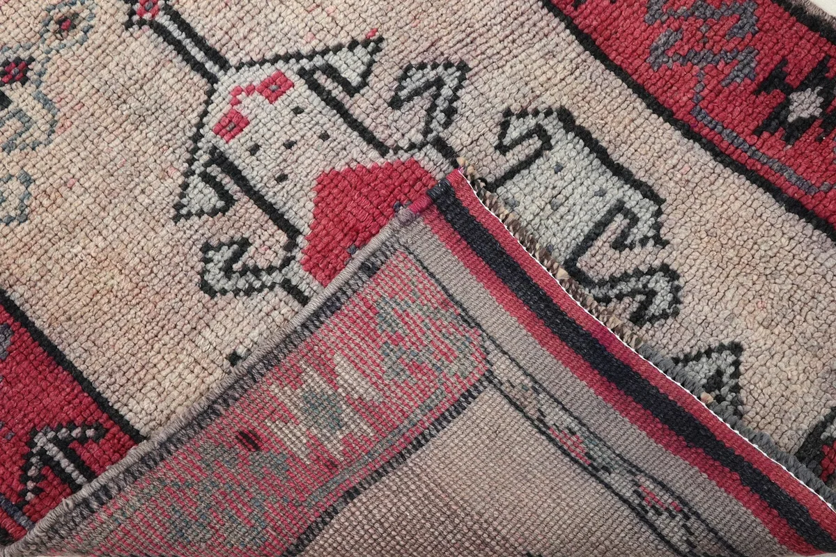 Corner of the rug folded to show the cotton foundation and the reverse side of the hand-knotting.
