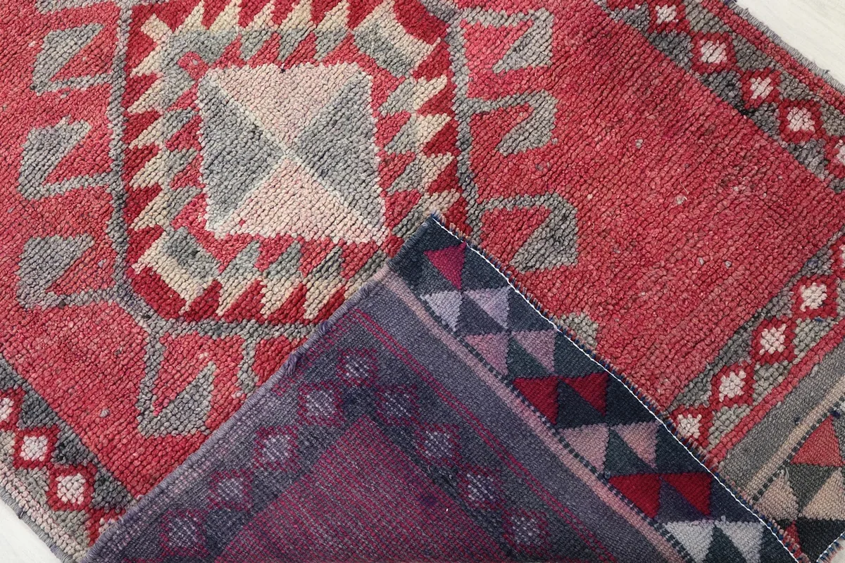 View of the back of the hand-knotted rug, revealing the foundation and knotting structure.