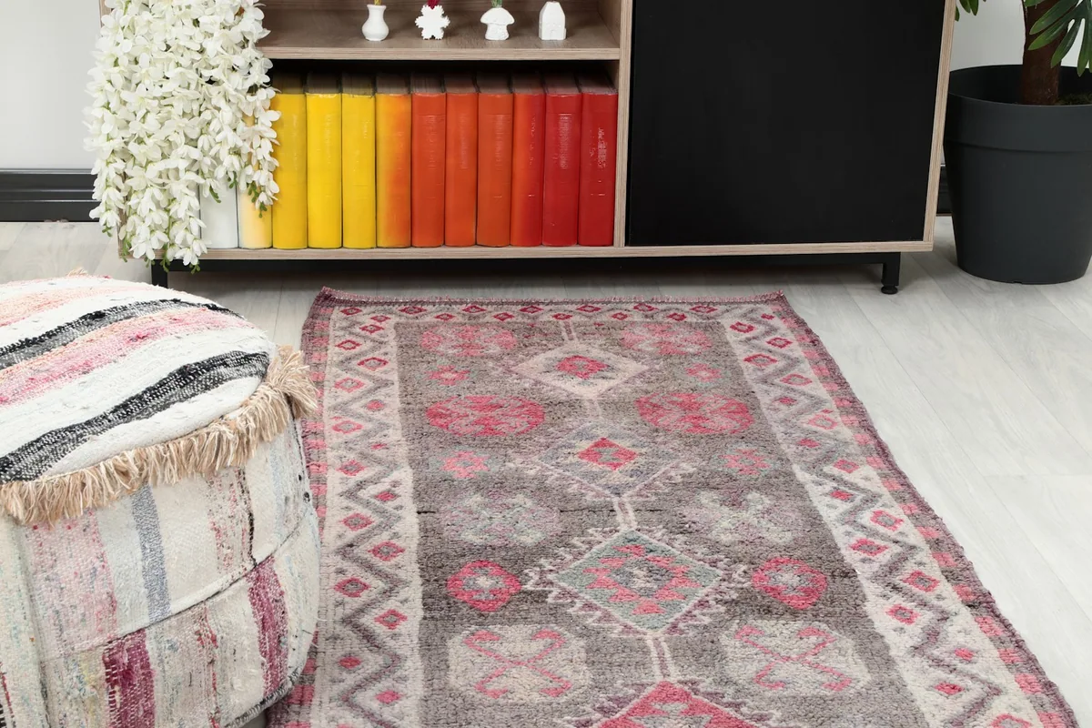 Close-up view of the runner rug's end, showing its placement near a decorative pouf and cabinet