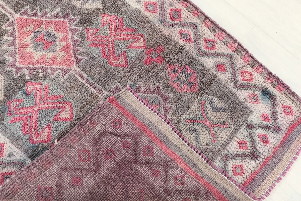 Close-up of the rug's low wool pile and the hand-knotted texture, with the back visible
