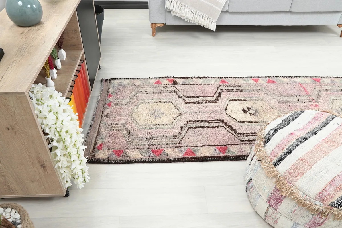 Runner rug extending through a room, viewed from a side perspective.