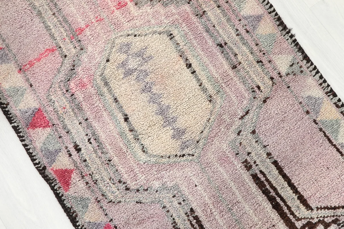 Close-up of a central ivory medallion with tribal motifs and surrounding rose field.