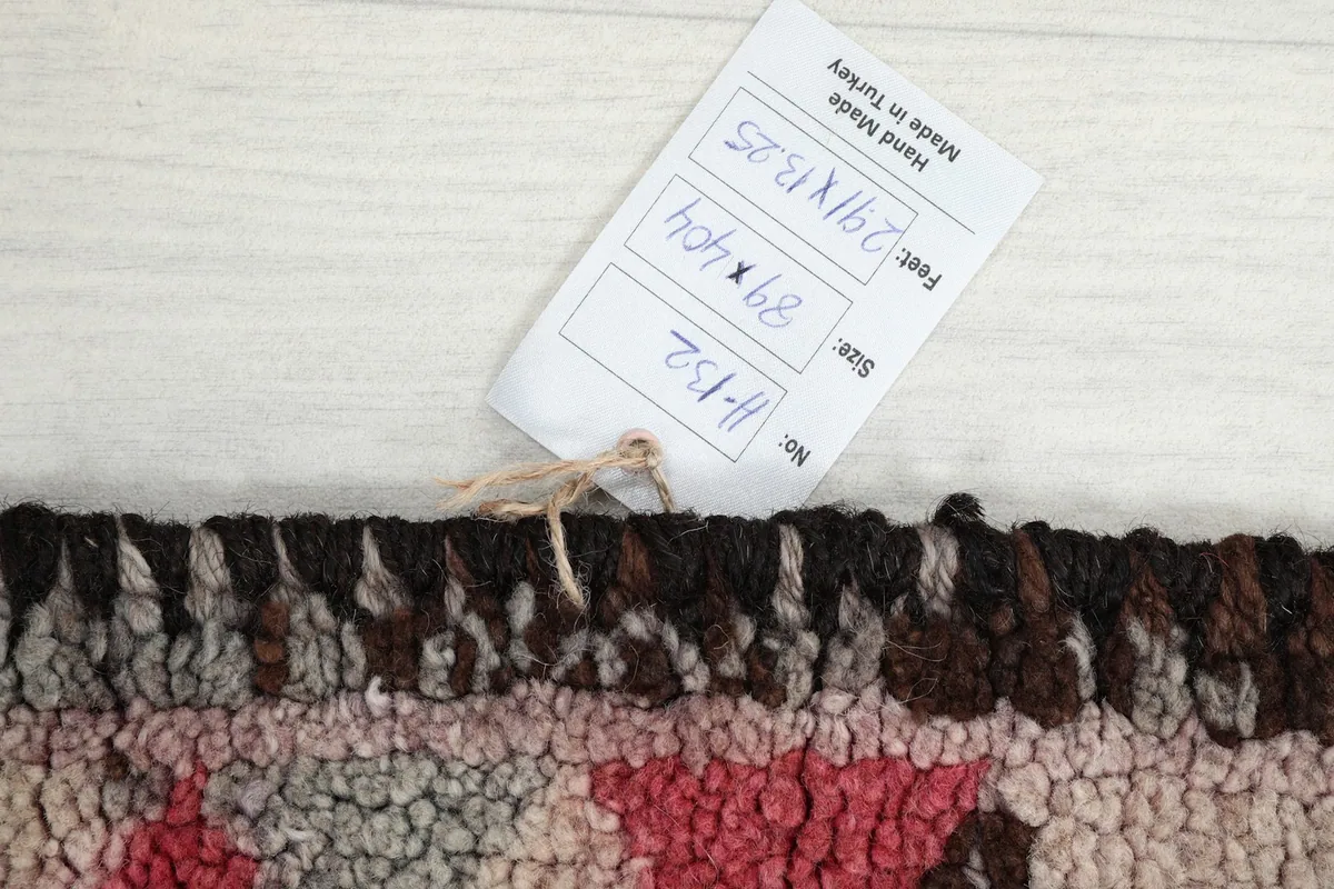 Tag showing the rug's dimensions in feet and centimeters, along with the inventory number.