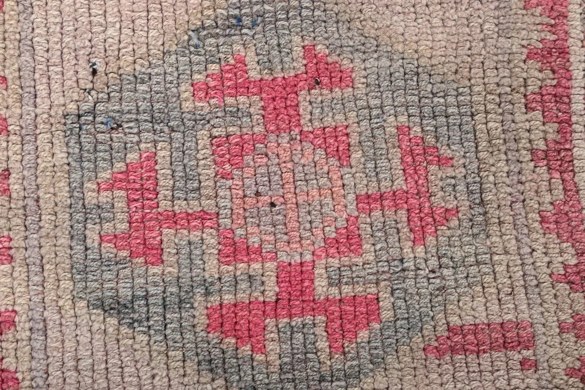 Extreme close-up of a single rose and blue geometric motif and wool pile