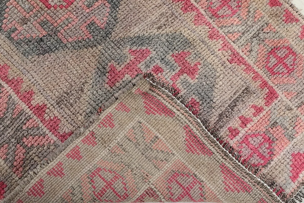 Folded corner of the rug revealing the hand-knotted cotton foundation and wool pile