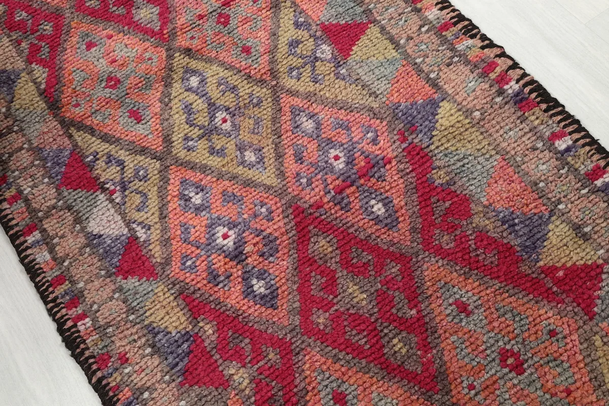 Angled shot showcasing the intricate geometric motifs and color variations within the rug's field
