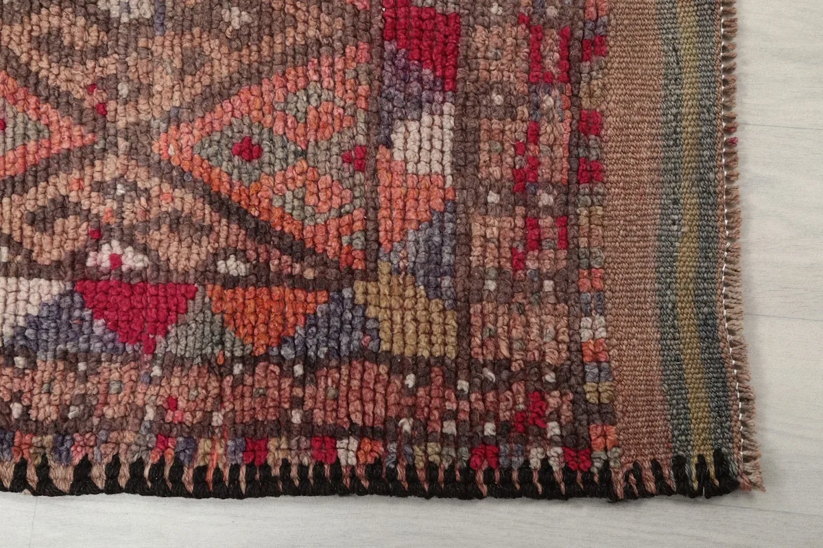 Detailed view of the rug's edge and fringe, showing the hand-knotted wool pile and cotton foundation