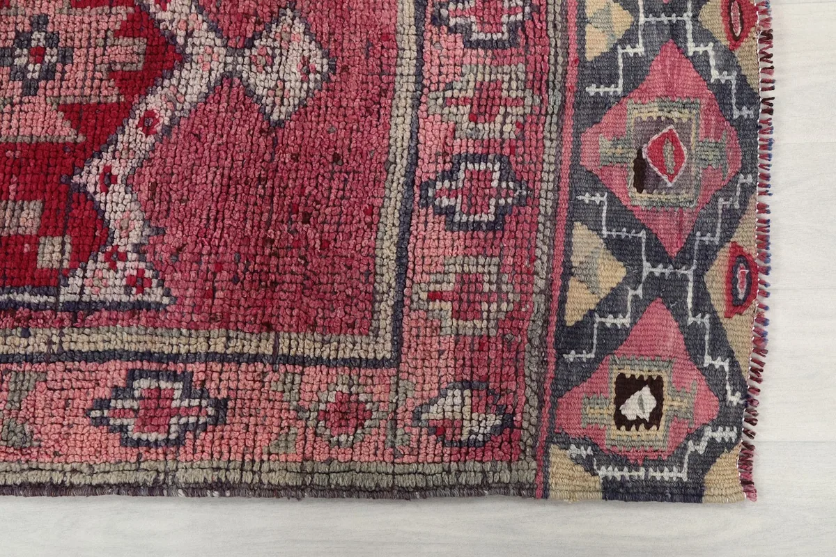 Detailed view of the intricate border design and corner of the vintage runner.