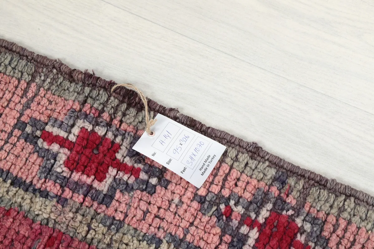 Detail of the rug's edge with a tag showing size information: 95 x 326 cm.