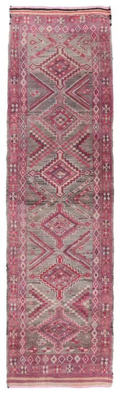 Full overhead view of the vintage rose and gray geometric Anatolian runner rug on a white background