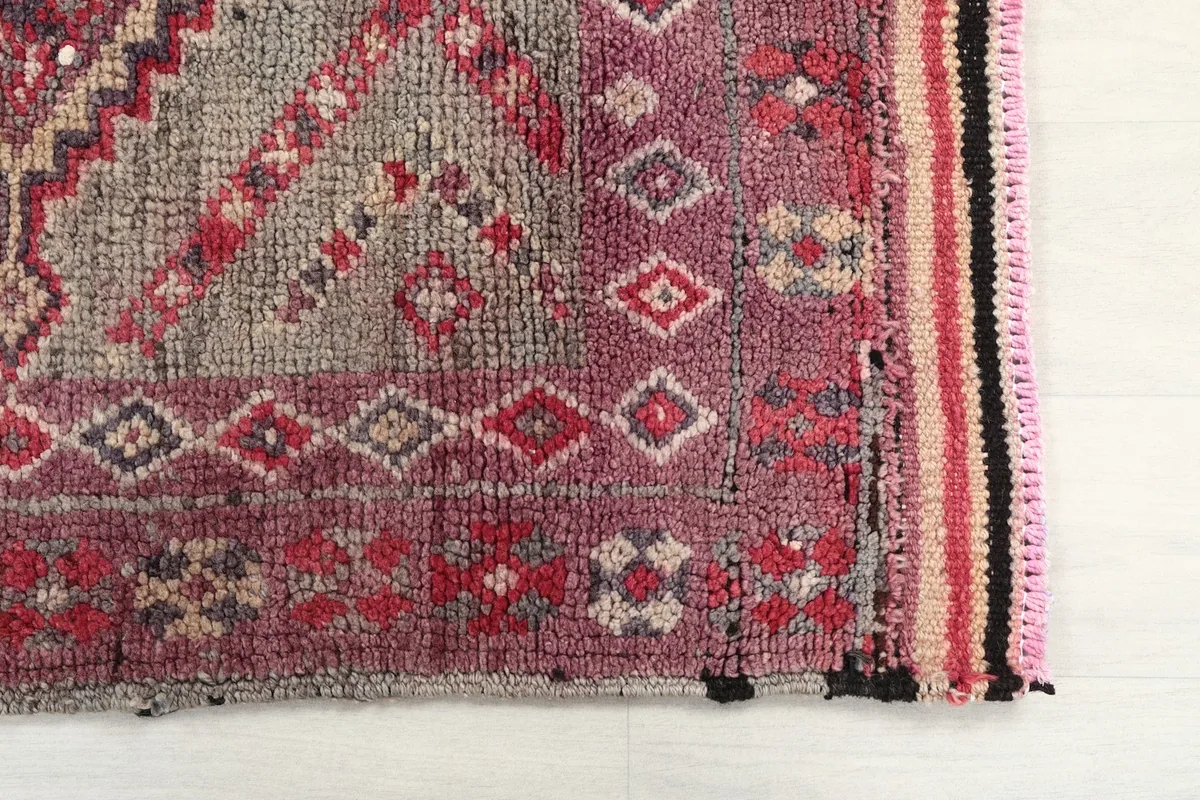 Detailed view of the rug's end, showing the intricate geometric motifs and border design