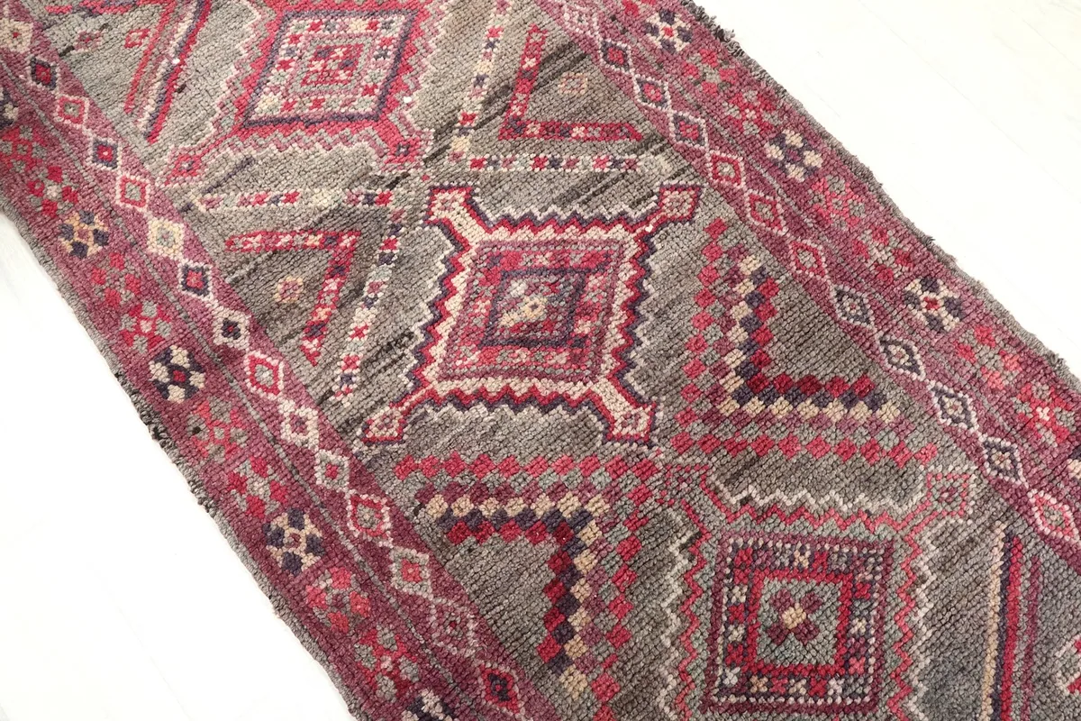 Close-up of the center geometric motifs in rose, gray, and brown tones on the runner