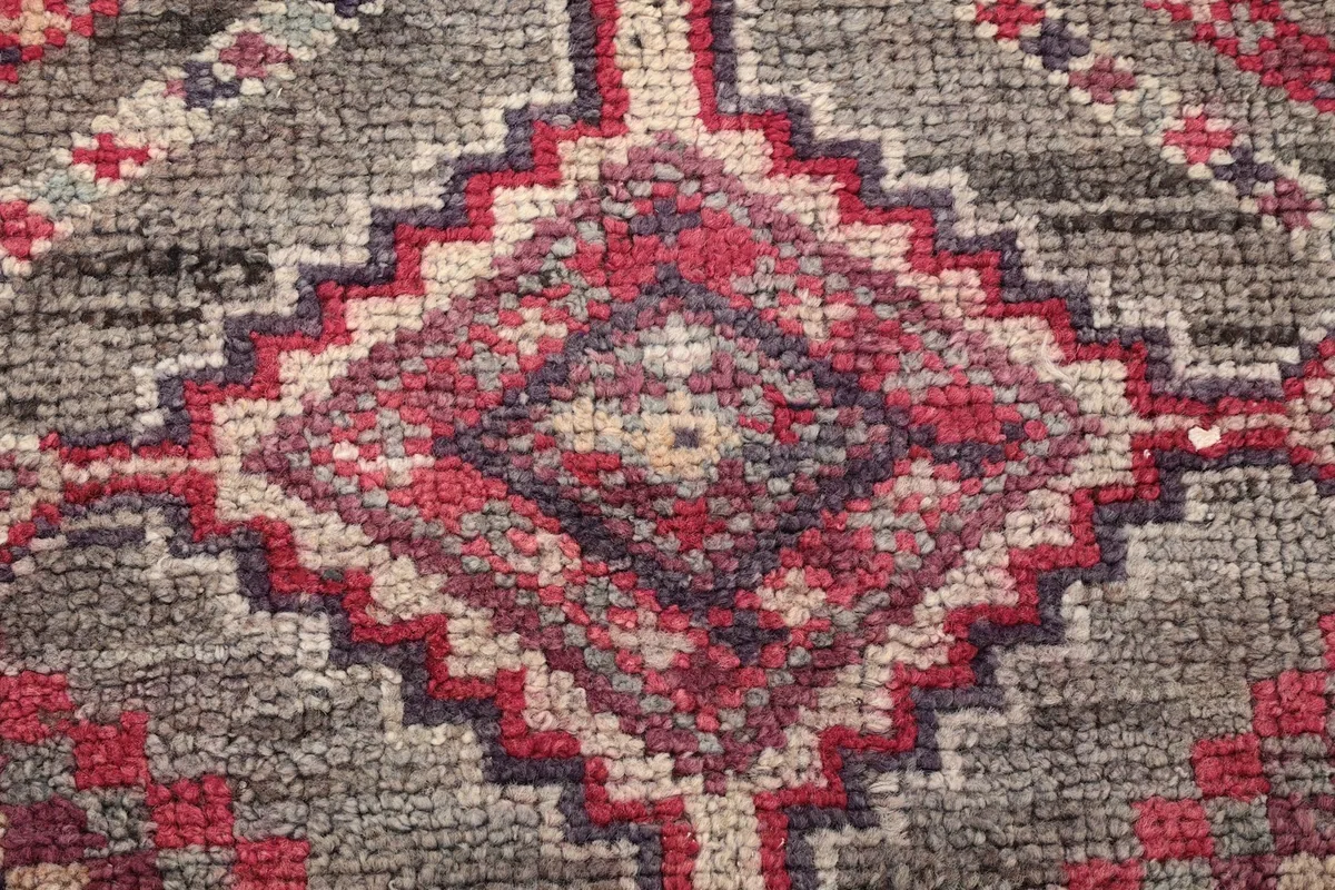 Macro view of the hand-knotted wool pile, showing texture and color variations of the rug