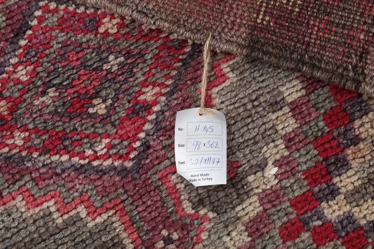Detail showing the rug's tag with size and origin information, alongside the pattern