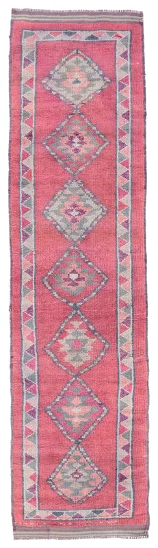 Full overhead view of a vintage rose geometric Anatolian runner rug on a white background.