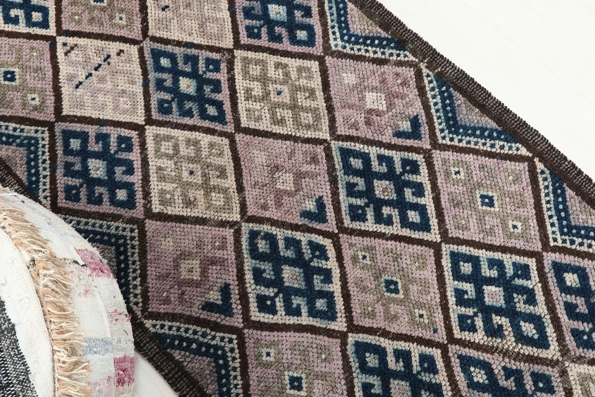 Overhead angled shot highlighting the diamond pattern and color variations of the rug