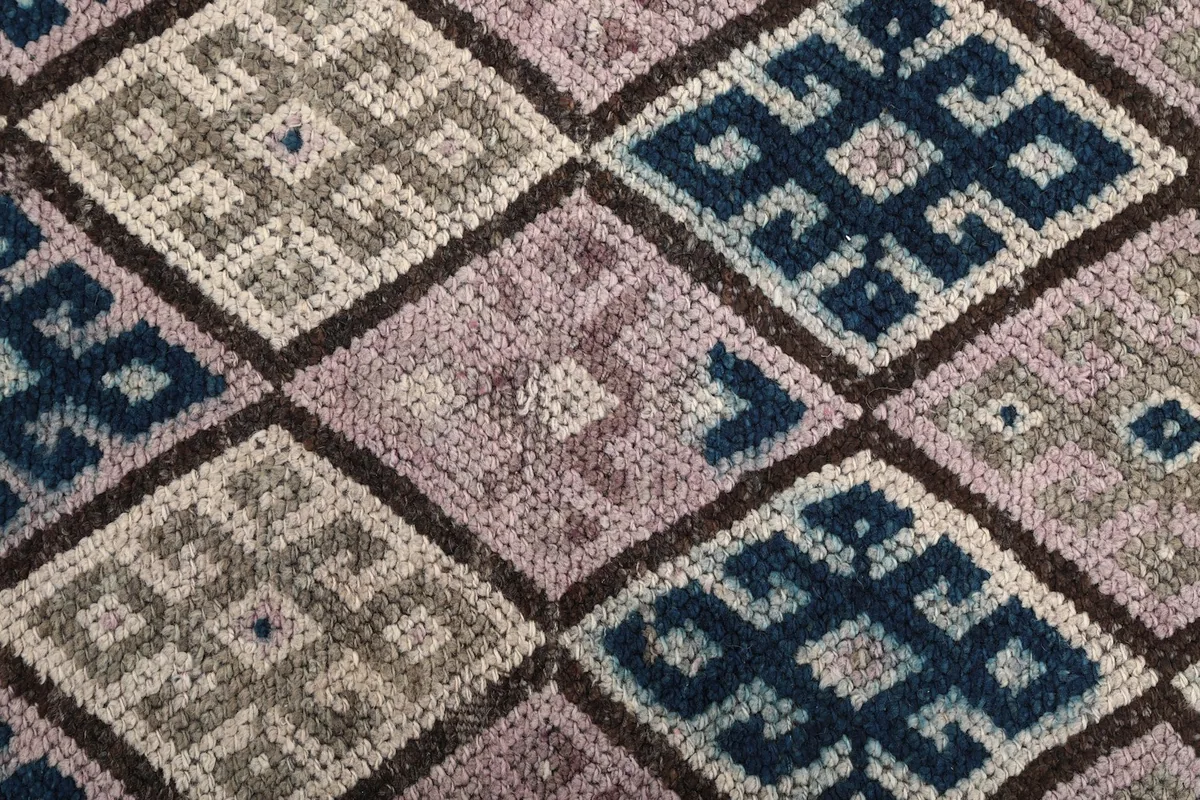 Close-up showing the low pile texture and hand-knotted wool of the rug's surface