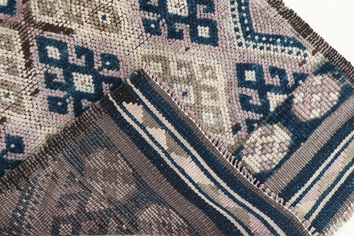 Folded back view of the rug showing the cotton foundation and reverse side of the knots