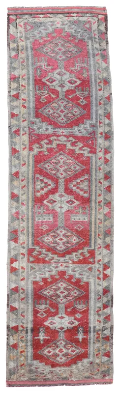 Full top view of the red and gray geometric Anatolian runner rug on a white background.