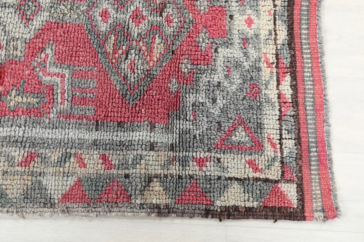 Detailed view of the rug's edge, border, and main field pattern, showing texture and color variations.