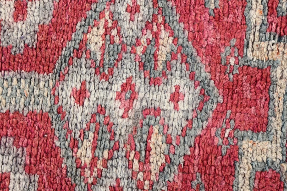 Extreme close-up showing the low wool pile and the hand-knotted texture of the rug.
