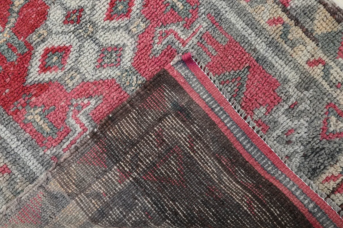 View of the back of the rug, revealing the cotton foundation and knotting structure.