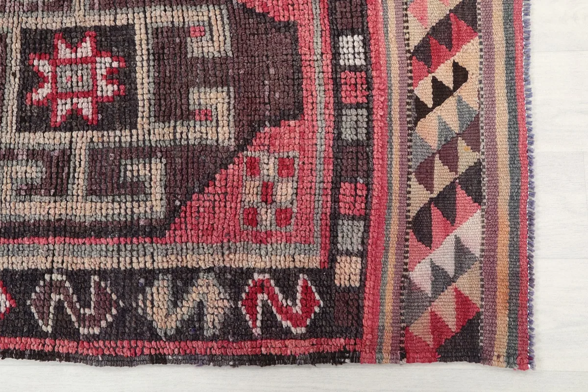 Close-up of the tribal border design and color variations at one end of the rug