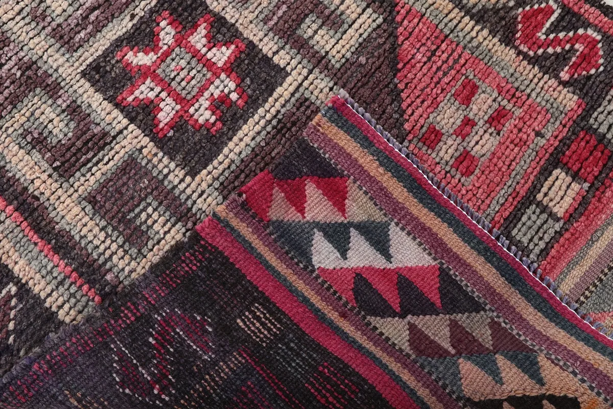 View of the back of the rug and a folded section, revealing the hand-knotted construction