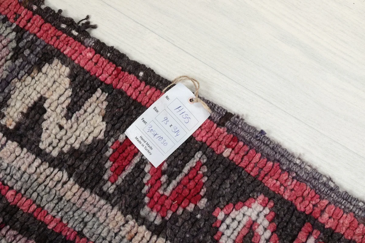 Close-up of the rug's border with a tag showing size and origin details