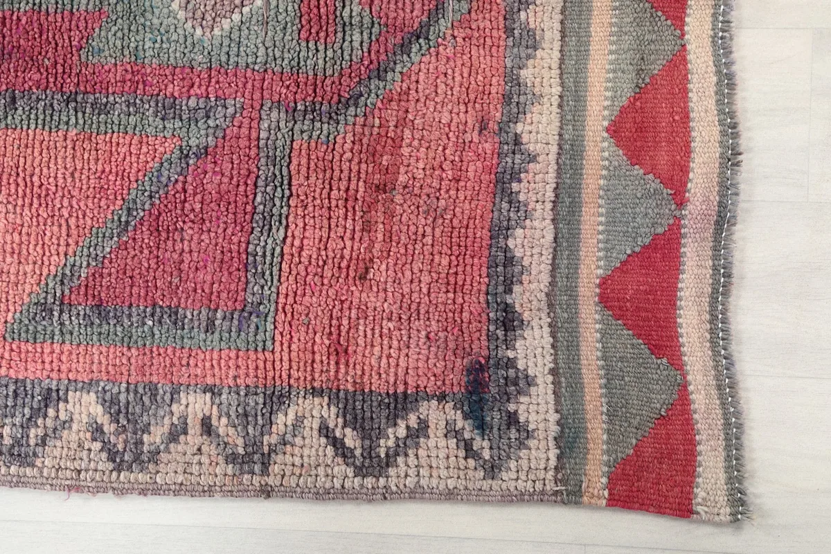 Detailed view of the rug's border and central geometric pattern with a red accent