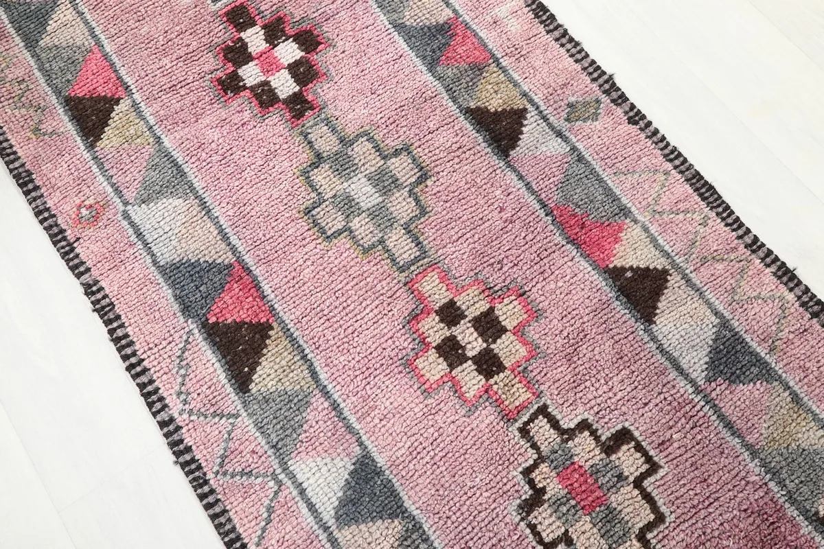 Overhead angle view of the runner's central pattern with rose, gray, black, and brown tones