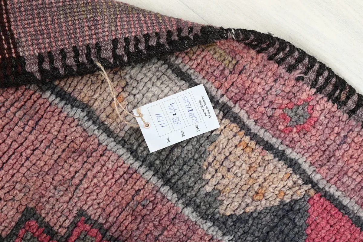 Close-up of the rug's surface with an attached product tag displaying size and origin information