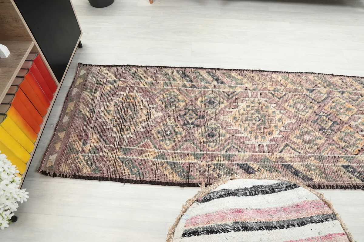 Wide angle view of the runner rug extending across a room, from a slightly elevated perspective.