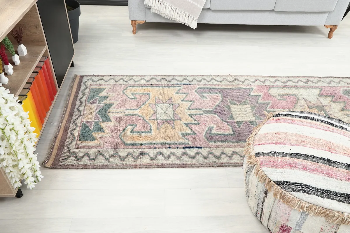 Long view of the runner in a room, showing its scale relative to a sofa and ottoman