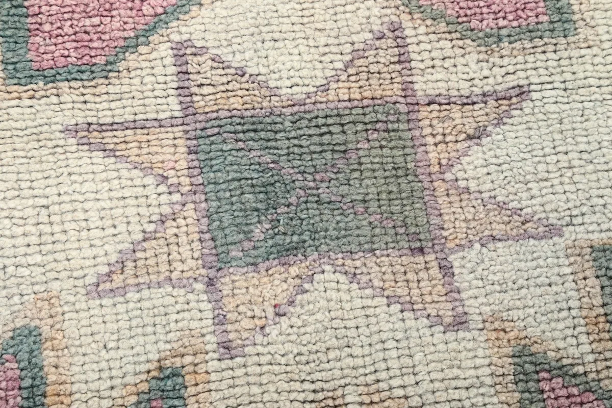 Macro shot of the low wool pile texture and hand-knotted weave of the rug