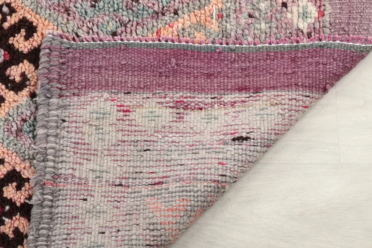 Close-up of the rug's low wool pile and the tightly woven cotton foundation, showing texture and construction.