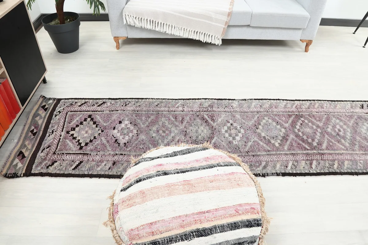 View of the runner rug in a living area, illustrating its ability to define a long space and add color.