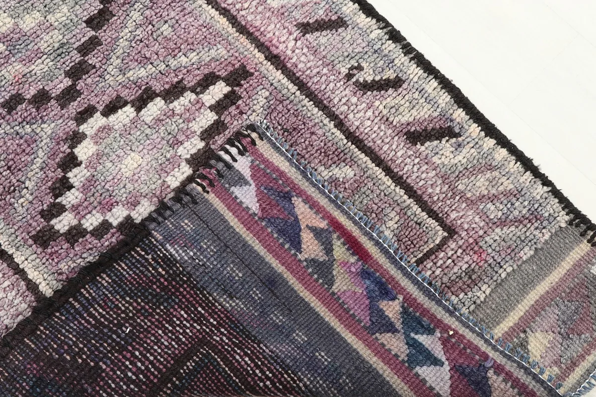 View of the back of the rug, revealing the cotton foundation and the craftsmanship of the hand-knotting.