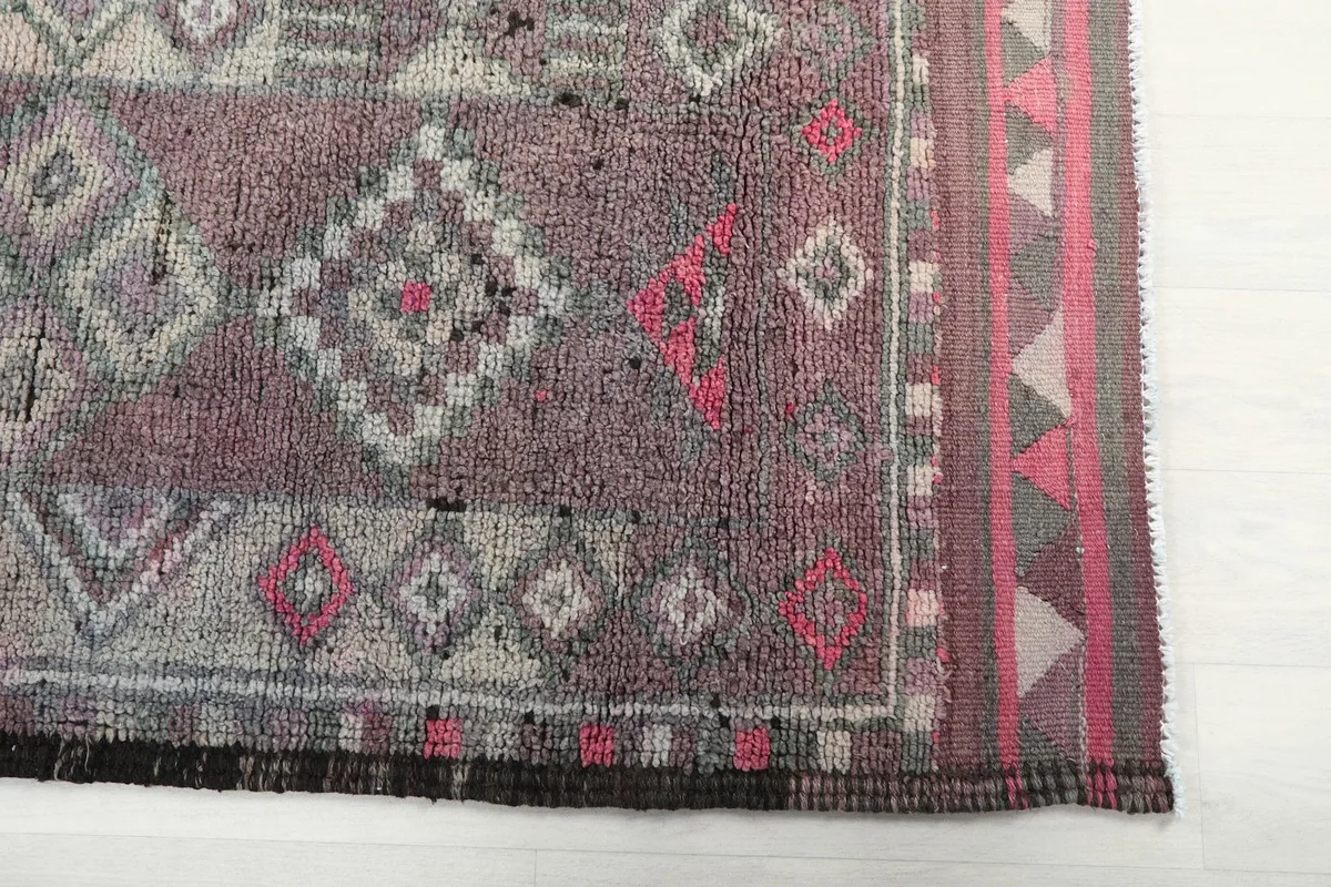 Detailed view of the rug's end, showing the geometric patterns and border design.