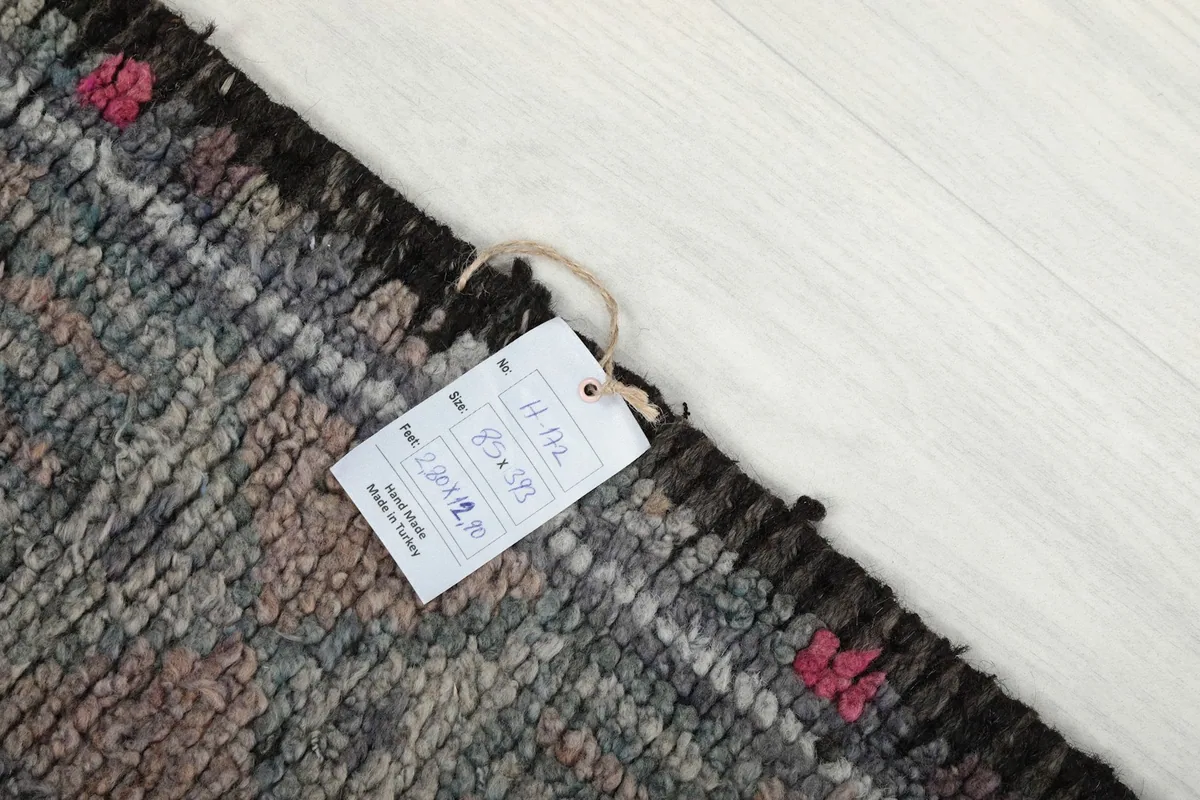 Image showing the rug's tag with size and origin details, resting on the rug surface.