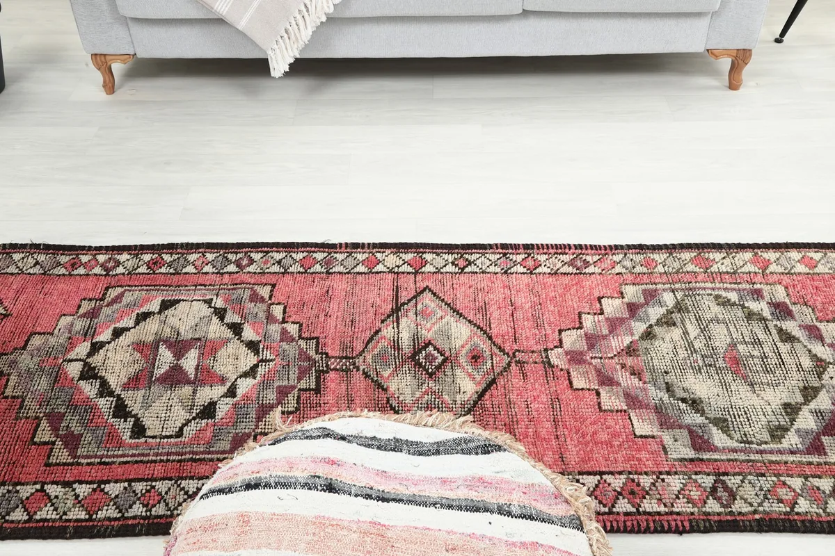 Top-down view of the runner rug in a room, with a pouf in the foreground